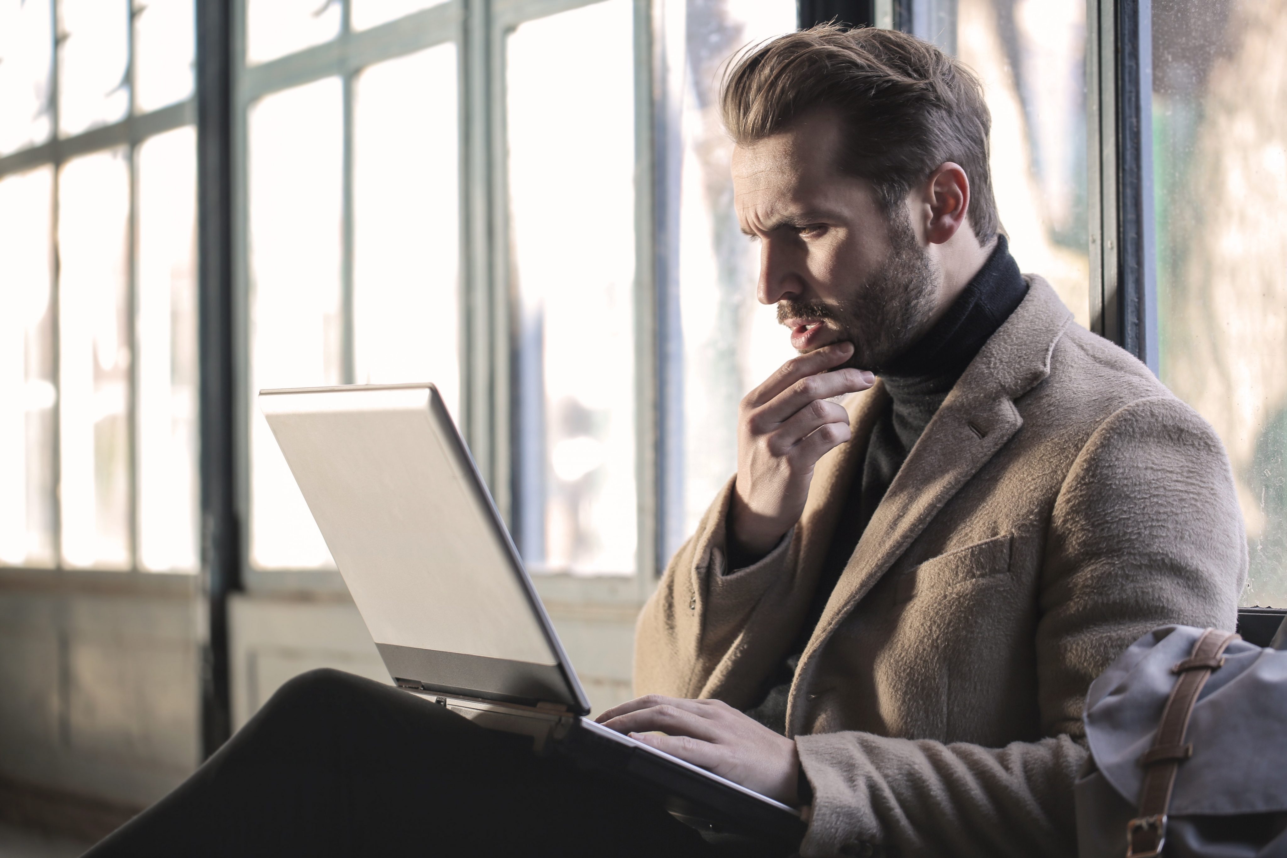 A businessman viewing his laptop in a cafe lounge environment